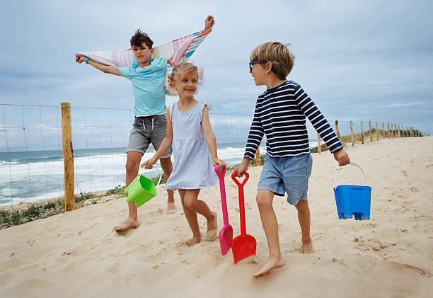 istock Kids chat, walk to beach with buckets and shovels at summer day 2256321849