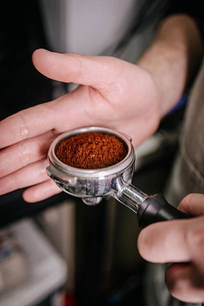 Barista holding portafilter with ground coffee