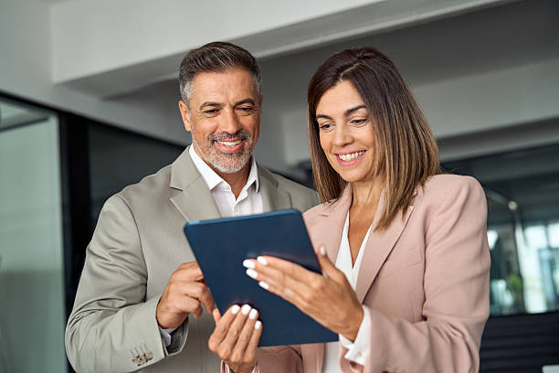 istock Happy busy business executives discuss digital strategy using tablet in office. 2256328867