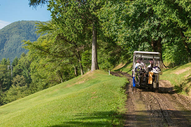 Male and female golfers riding golf carts at a golf course