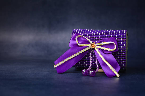 Elegant purple gift box with satin ribbon. Luxury present flat lay with copy space