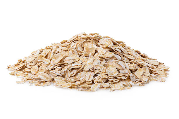 A pile of rolled oats isolated on a white background, authentic photograph, not AI-generated