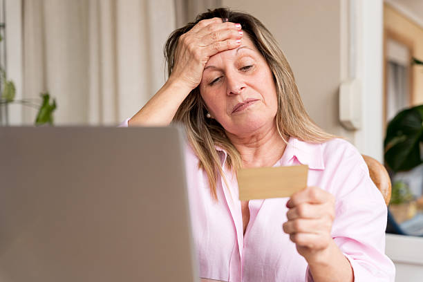 istock Senior woman feeling stressed and frustrated while looking at a credit card and using a laptop for online payments 2256401757