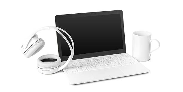 A laptop sits on a desk alongside headphones and a coffee cup, suggesting a work environment.