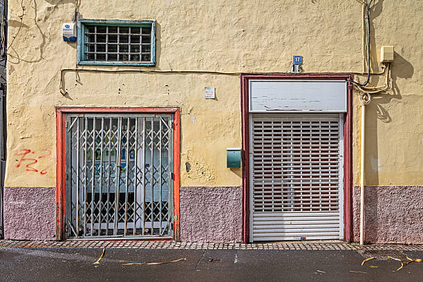 Santa Cruz, Tenerife, Spain, Europe - December 13th 2025: Small shops in Santa Cruz, the main city of Tenerife in the Canary Islands, are seen closed with heavy metal security grilles during the midday siesta period. Although winter temperatures in the subtropical climate are mild rather than hot, the tradition of closing for a few hours in the middle of the day is still widely observed. The robust grilles suggest concerns about potential break‑ins, even in an otherwise calm and peaceful city environment.