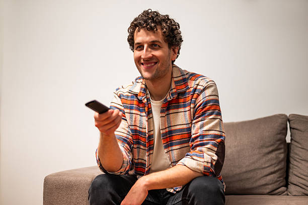 istock Relaxed young man watching tv at home 2256418037