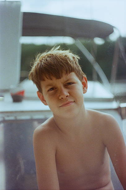 A teenage boy walking in spa pool within a water park. He is walking under the cascading streams.\nSummer vacations day.\nShot with Canon R5