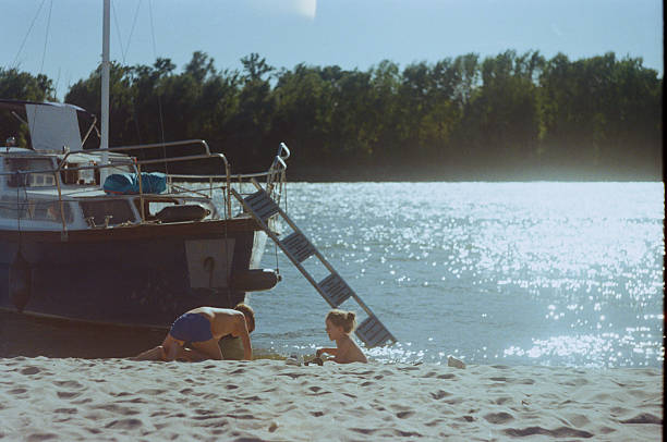 istock Brother and sister playing by a river boat 2256420579