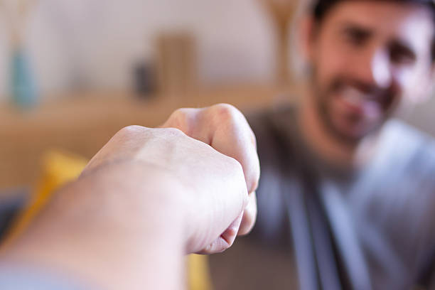Two hands making a fist bump, showing support and friendship