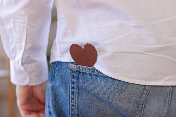 Brown paper heart finding a place in a back pocket of blue jeans and a white shirt