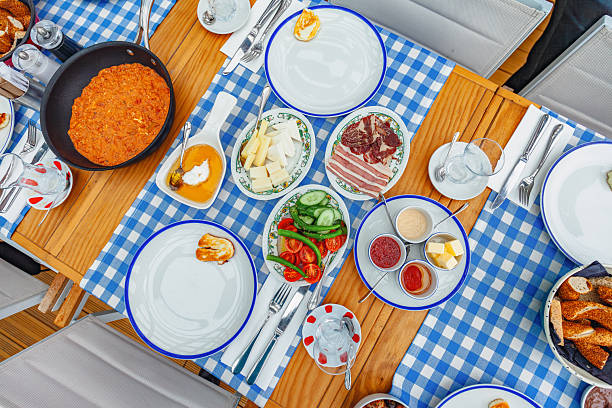 Delicious Omelette in Cast Iron Pan on Wooden Board with Turkish Tea and Breakfast Dishes for Restaurant Menu and Food Photography. High quality photo