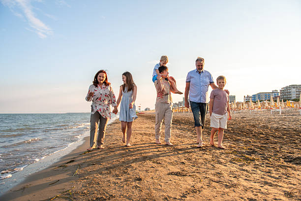istock Group of Relatives Enjoying a Stroll by the Sea 2256423524