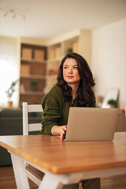 istock Woman working on laptop while thinking at home 2256433383