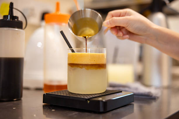 Barista woman is preparing fresh espresso with lemon juice.