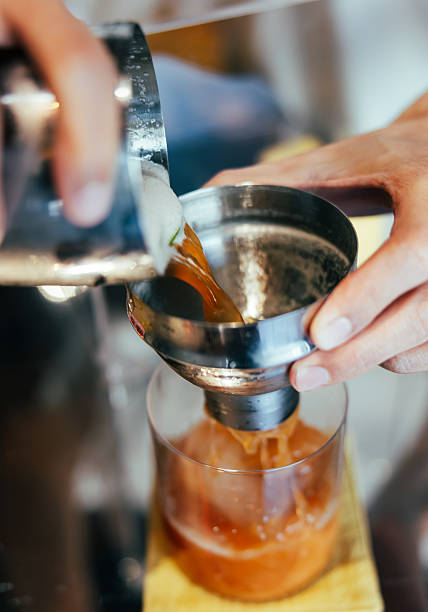 Barista is preparing clod brew coffee with shaker.