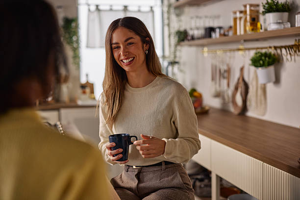 istock Smiling woman sharing a friendly moment with a mug in a cozy kitchen cafe setting 2256437130