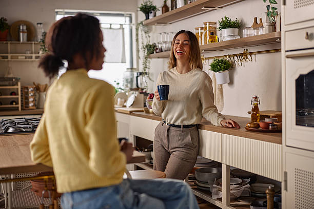 istock Two friends share a laugh over coffee in a bright, modern kitchen 2256437161