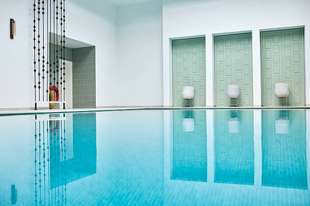 View of a pool at water level in a modern, luxurious building.