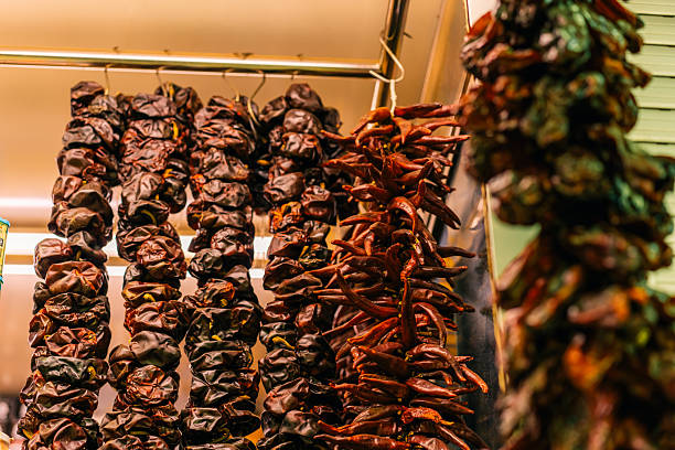 Dried chili peppers hanging from strings or threads in a market in Spain. High quality photo