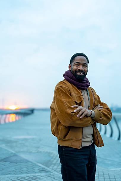 istock Smiling man standing outdoors at sunset with arms crossed 2256453690
