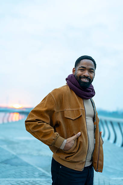 istock Smiling young adult man standing outdoors during sunset 2256453708