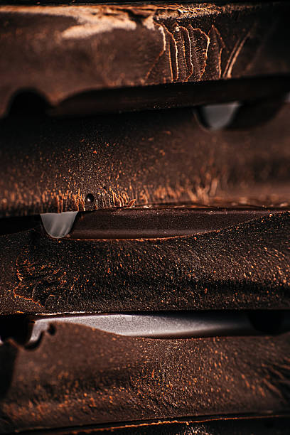 Dark chocolate texture background with layered chocolate pieces close up