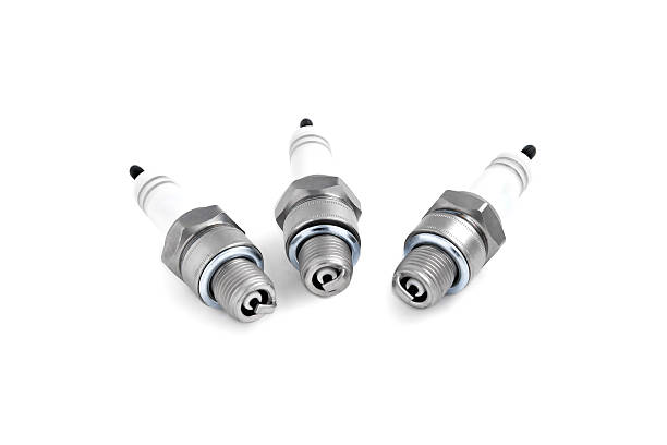 Automotive spark plugs for an internal combustion engine on a white background, close-up selective focus