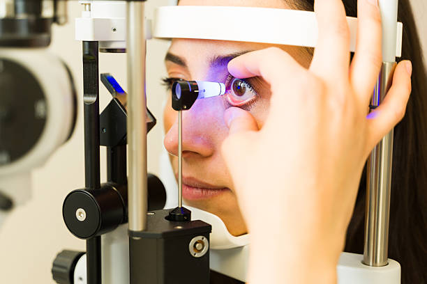 Female patient undergoing eye examination at ophthalmologist office, doctor performing tonometer test for glaucoma diagnosis