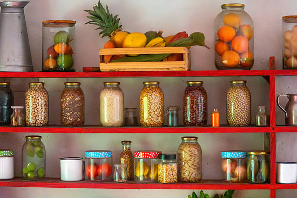 A vibrant kitchen shelf filled with jars of preserved fruits, vegetables, and ingredients, showcasing an organized and colorful culinary display.