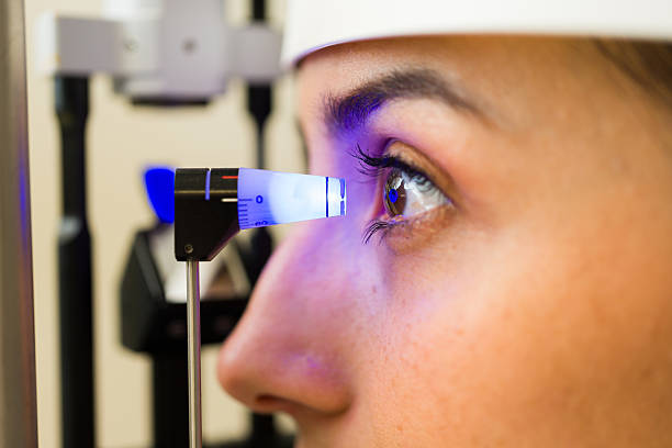 Patient receiving a diagnostic eye exam, checking intraocular pressure with a tonometer to screen for glaucoma