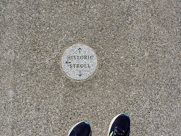 Historic stroll this way, a sidewalk marker direction with feet.