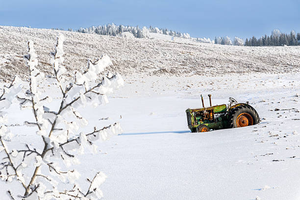 Scenic winter rural landscape with an abandoned old rusty tractor