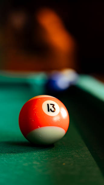 Playing pool with number 13 billiard ball on green felt