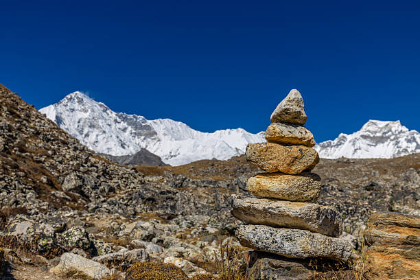 Early morning sun bursting over the jagged summit of Thamserku high in the Himalayan mountain wilderness of Nepal.