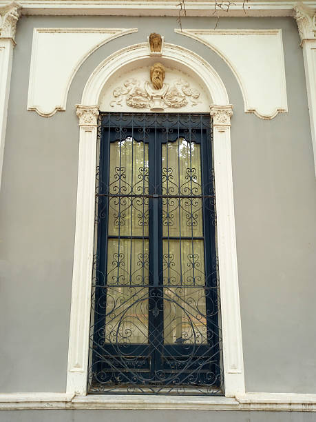 San Antonio de Areco, Argentina - Dec 14, 2025: A window with an ornate wrought iron grille set within a traditional classical facade