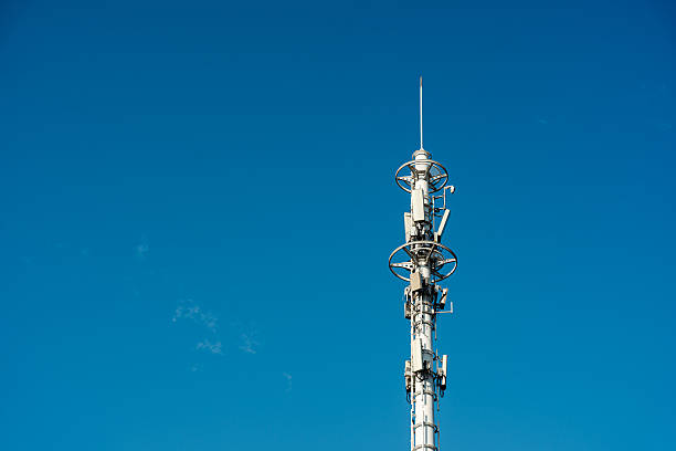 5G telecommunications base station tower against a sunny blue sky