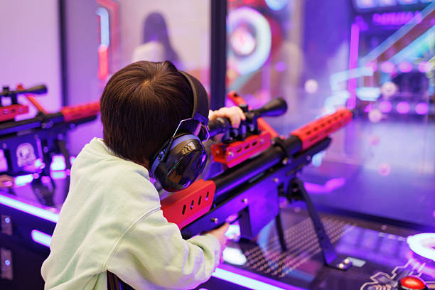 A little boy is playing shooting games at the amusement park