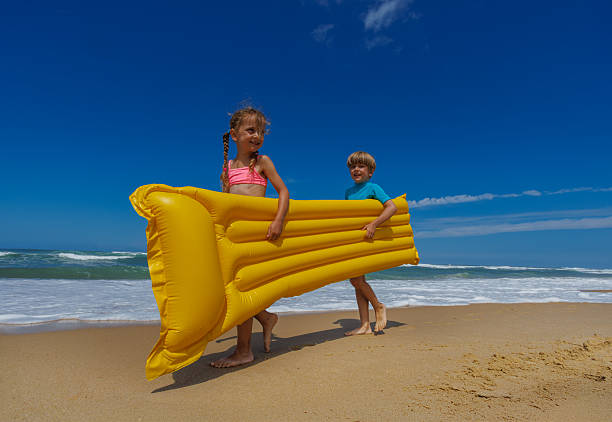 Happy Asian Family, Summer Vacation, Mother and daughter Open arms playing plane flying together in a car on the beach. Holiday and Car Travel