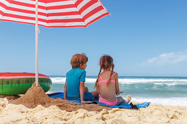 girls on the beach with umbrellas on a rainy day.