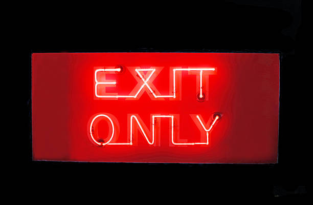 Orange-red neon 'EXIT ONLY' sign as seen from a sidewalk along U.S. Route 66 in Glendora, California.