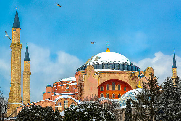 Hagia Sophia (Ayasofya) covered in fresh snow under a dramatic cloudy sky in Istanbul, Turkey. A peaceful winter cityscape featuring an iconic historic landmark and Islamic-era architecture.