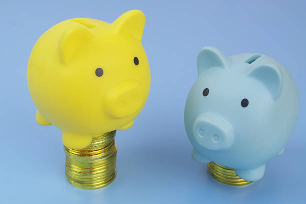 Different piggy banks on gold coins stacks. Different capitalization of financial funds and banks.