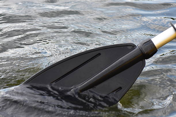 Black plastic paddle on the water surface with water drops in the background
