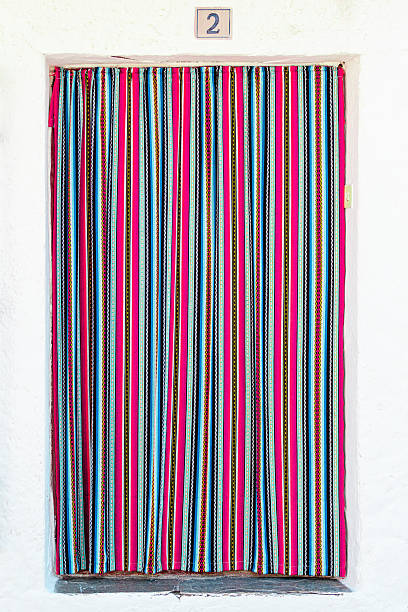 A vibrant striped curtain in bright colors covers an entrance, adding charm and character to the outdoor space.