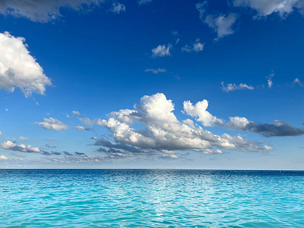 Dramatic storm clouds over turquoise Caribbean Sea, dark weather front and horizon, tropical seascape,