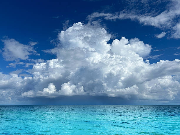 Dramatic storm clouds over turquoise Caribbean Sea, dark weather front and horizon, tropical seascape,