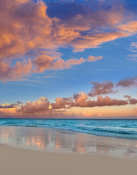 Sunset over tropical turquoise beach, pink clouds and transparent water on white sand