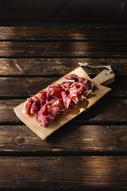 Raw ham platter on wooden background