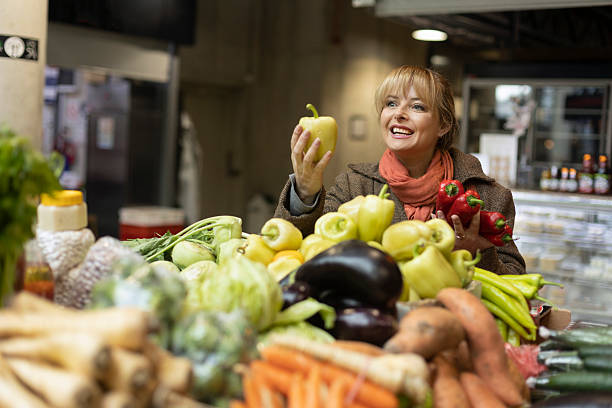Mature woman buying vegetables at a farmer's market. About 50 years old, Caucasian female.