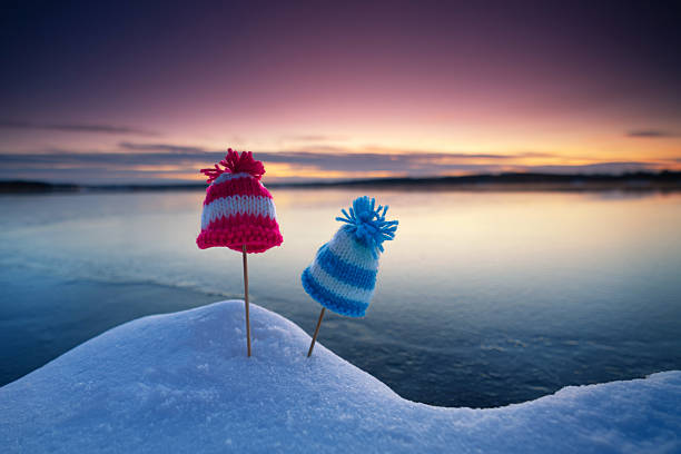 cute self knitted whimsical hats on the winter beach in sunset light